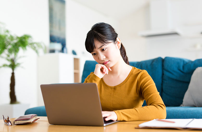 浮気調査の料金にかんするFAQを読む女性